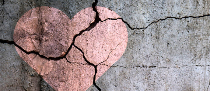 pink heart painted on concrete ground with cracks through it
