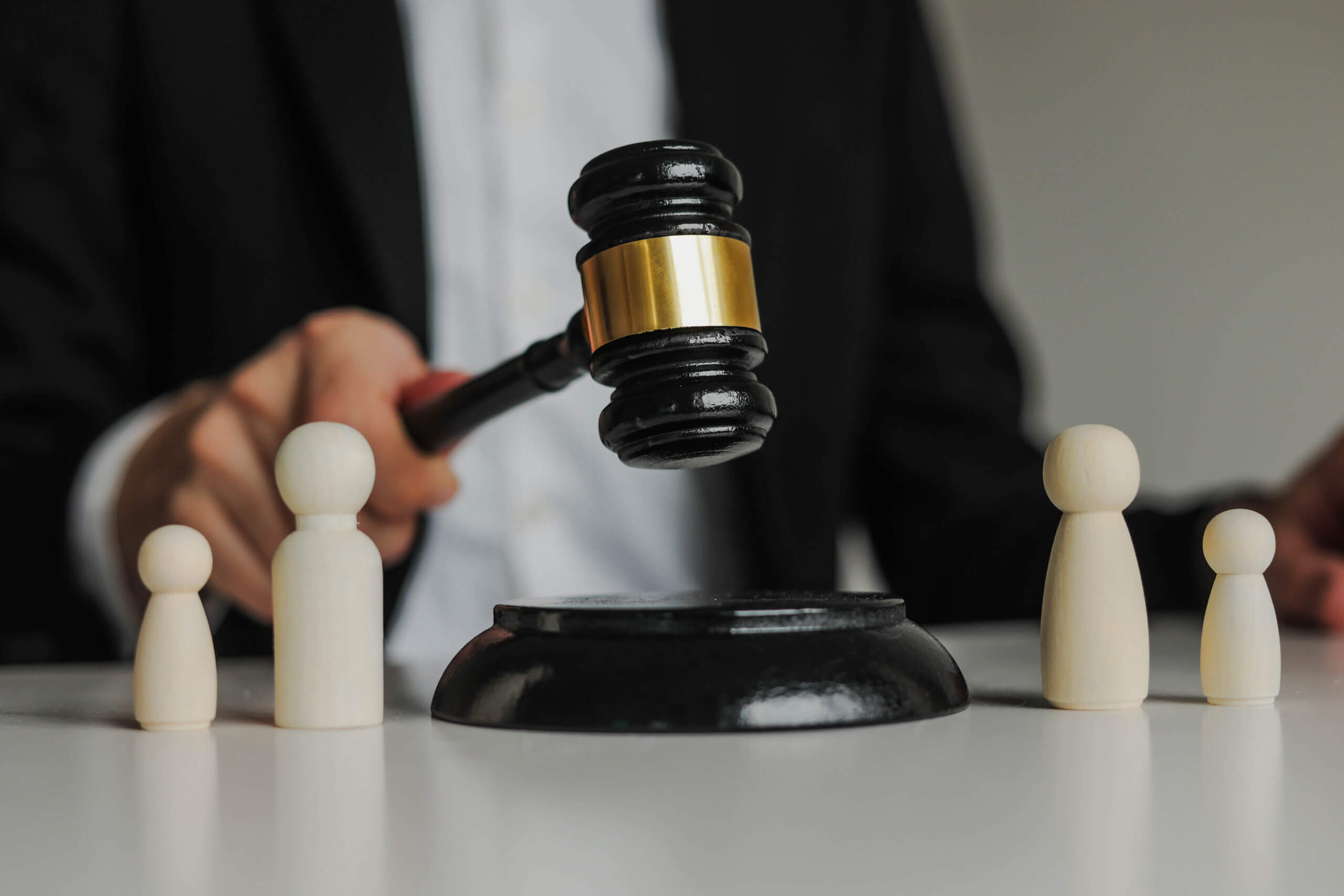 Figures of family are separated by judge's gavel. Family law, divorce lawyer and alimony concept.