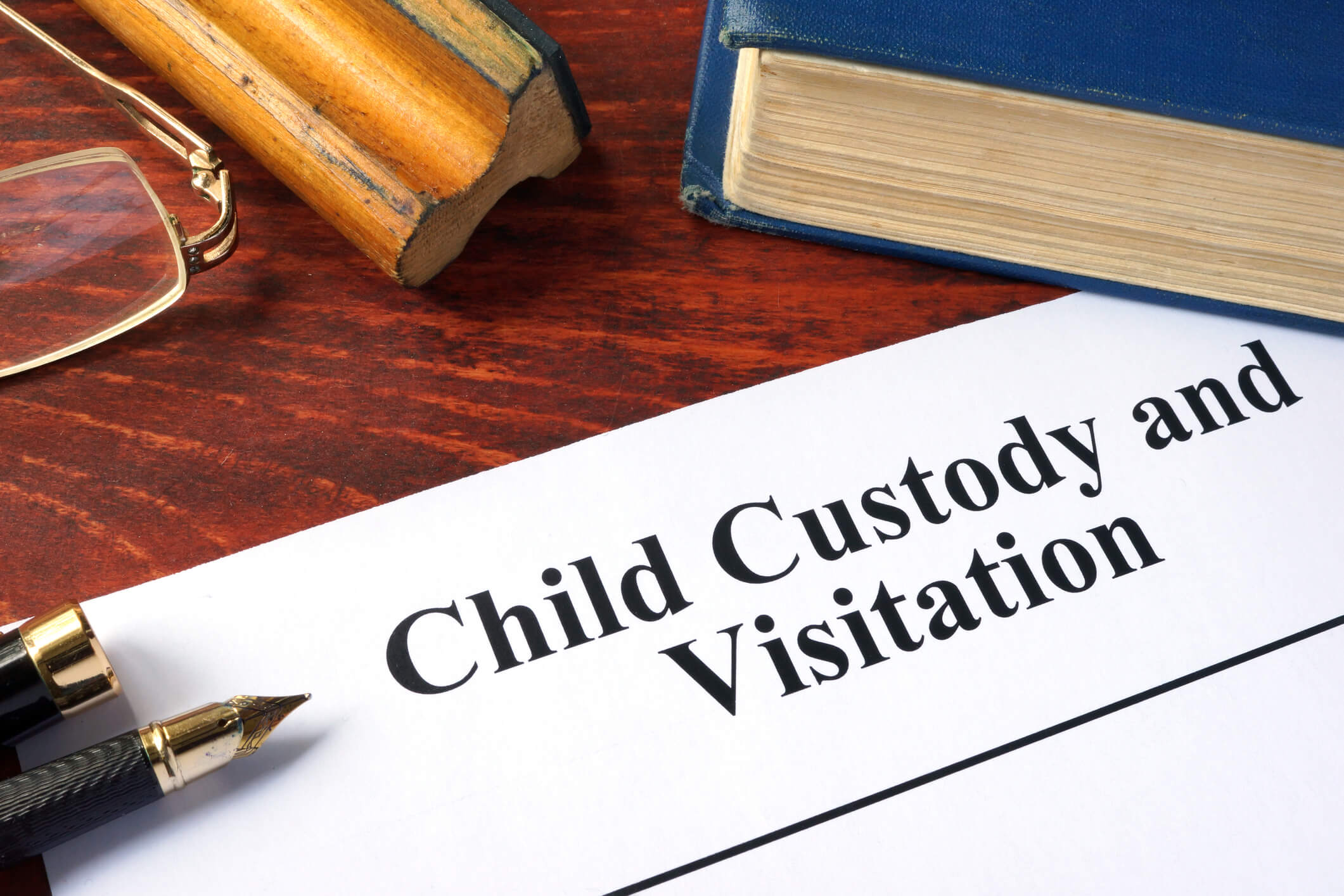 Child Custody and Visitation written on a paper and a book.